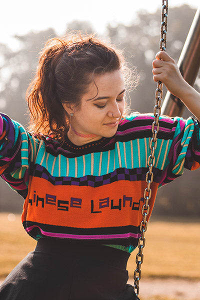 Female sat on swing wearing Chinese Laundry jumper